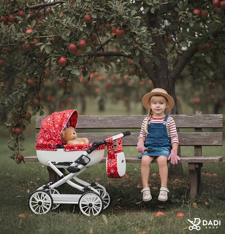 Dziewczynka w kapeluszu siedzi na ławce obok wózka dla lalek w sadzie wśród jabłoni.